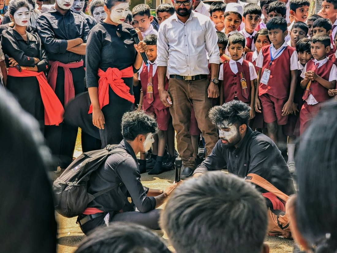 Facilitator addressing schoolchildren during the street drama performance