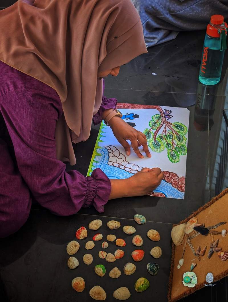 Participant drawing with natural materials nearby